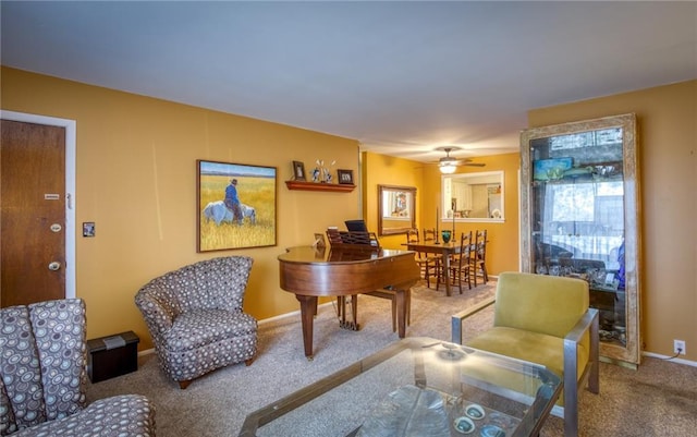 living area featuring baseboards, carpet, and a ceiling fan