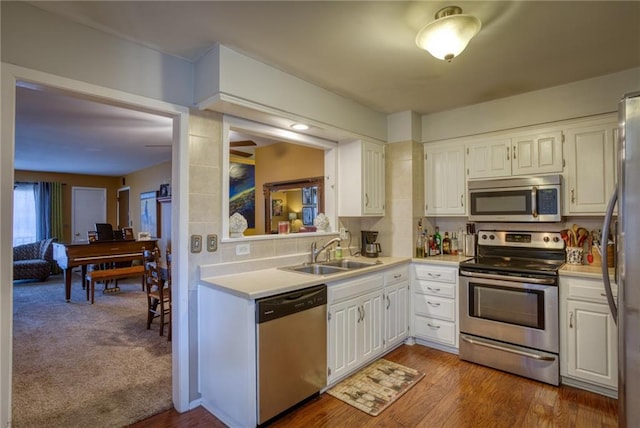 kitchen featuring a sink, appliances with stainless steel finishes, white cabinetry, and light countertops