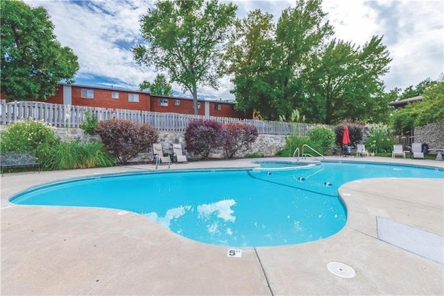 view of swimming pool featuring fence, a fenced in pool, and a patio area