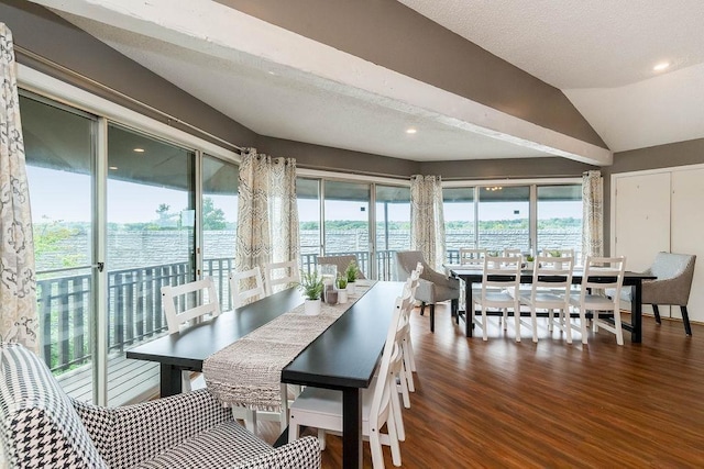 dining space with a water view, vaulted ceiling, recessed lighting, and wood finished floors