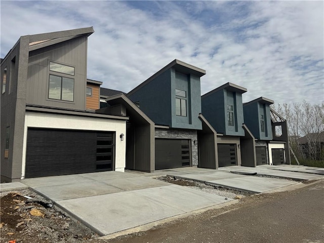 22150 W 116th Ter, Olathe, KS 66061 - contemporary home featuring an attached garage, stucco siding, and driveway