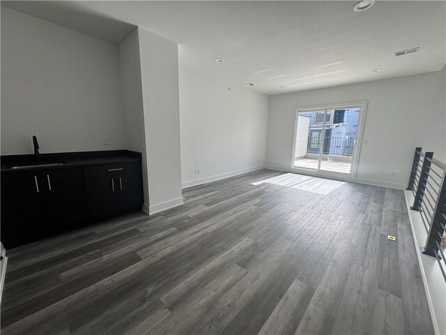 22150 W 116th Ter, Olathe, KS 66061 - unfurnished living room with visible vents, wood finished floors, baseboards, recessed lighting, and a sink