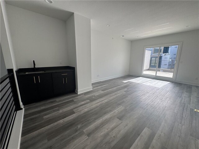 22150 W 116th Ter, Olathe, KS 66061 - unfurnished living room with baseboards, a sink, and light wood finished floors
