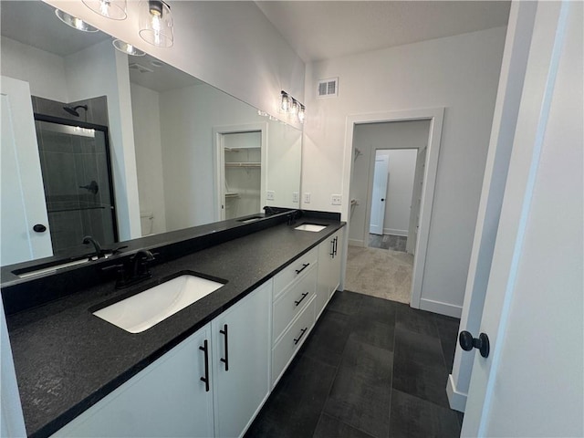 bathroom with visible vents, a sink, double vanity, and a shower stall