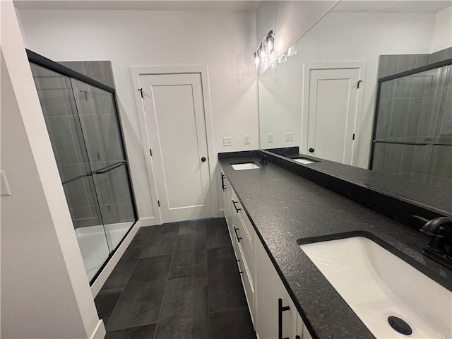 full bath with a sink, a shower stall, and double vanity