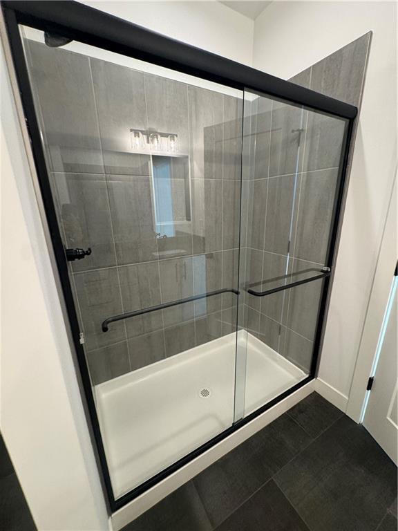 full bath with tile patterned floors and a shower stall