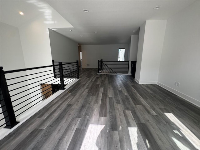 spare room with recessed lighting, baseboards, and wood finished floors