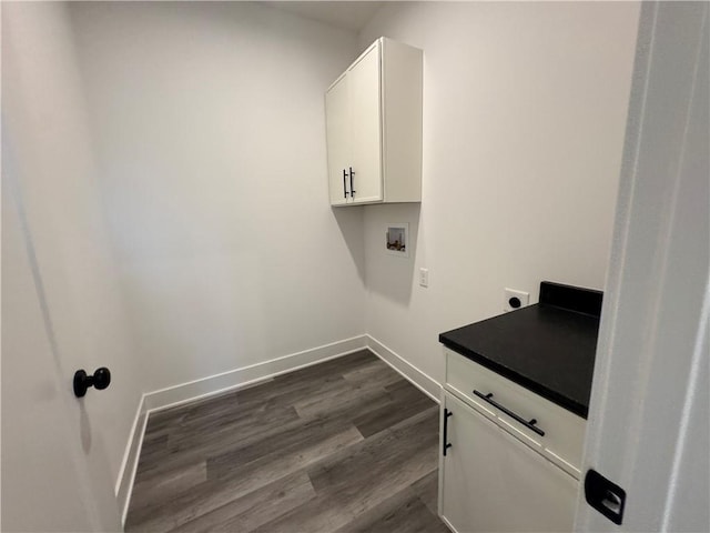 washroom with electric dryer hookup, cabinet space, baseboards, hookup for a washing machine, and dark wood-type flooring