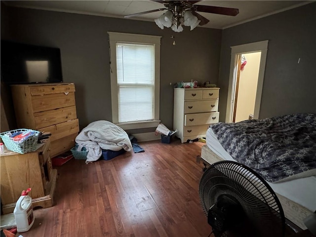 bedroom with crown molding, a ceiling fan, and wood finished floors