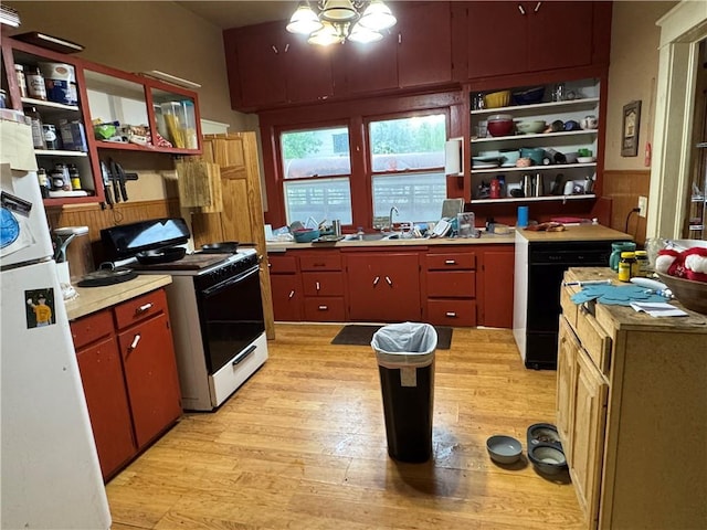 kitchen featuring electric range, open shelves, a sink, light wood finished floors, and freestanding refrigerator