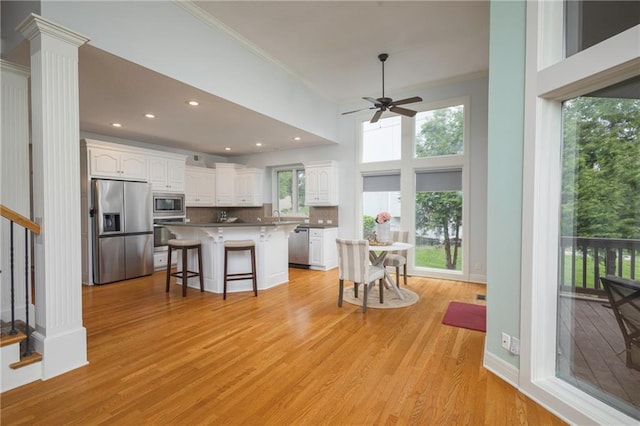 kitchen with crown molding, white cabinets, a ceiling fan, and stainless steel appliances