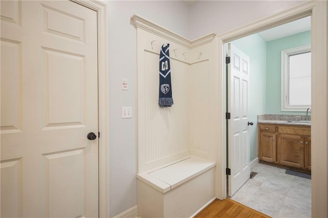 mudroom with baseboards and a sink