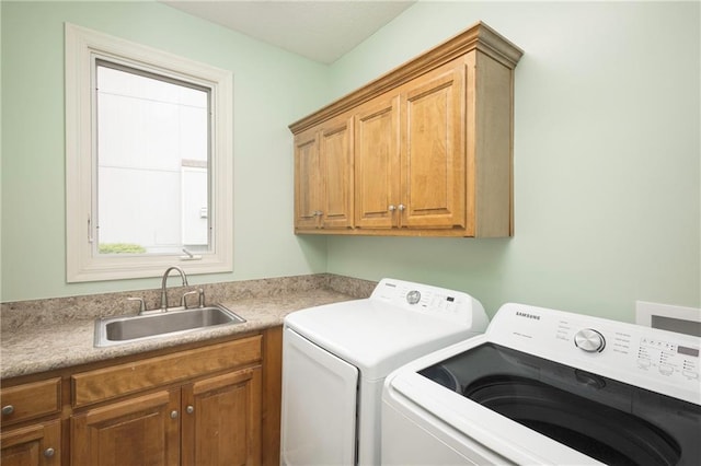 washroom with a sink, cabinet space, and washer and dryer