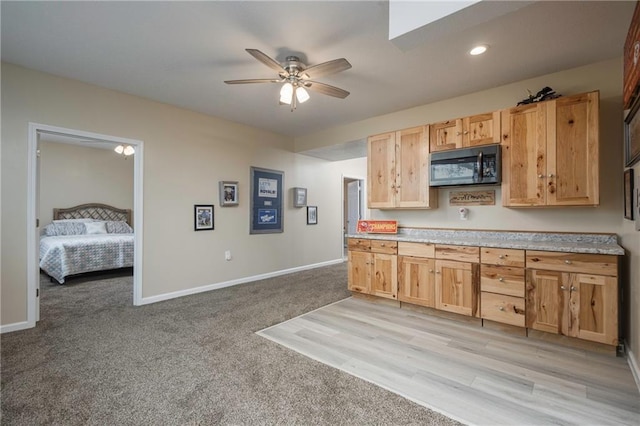kitchen with light brown cabinetry, baseboards, ceiling fan, light colored carpet, and light countertops