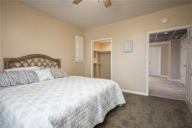 bedroom featuring a closet, a ceiling fan, baseboards, a walk in closet, and carpet flooring