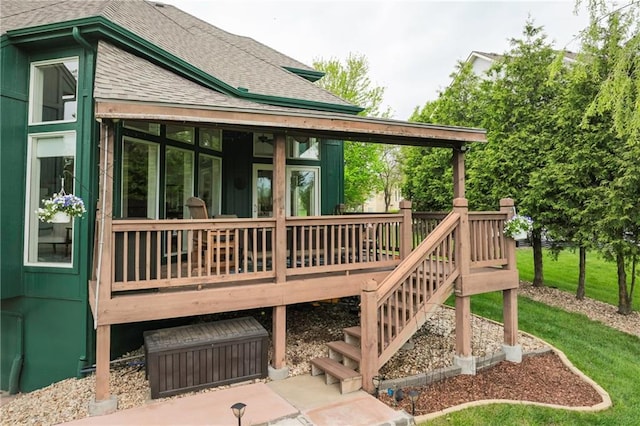 back of property with stairs, a shingled roof, a wooden deck, and a sunroom