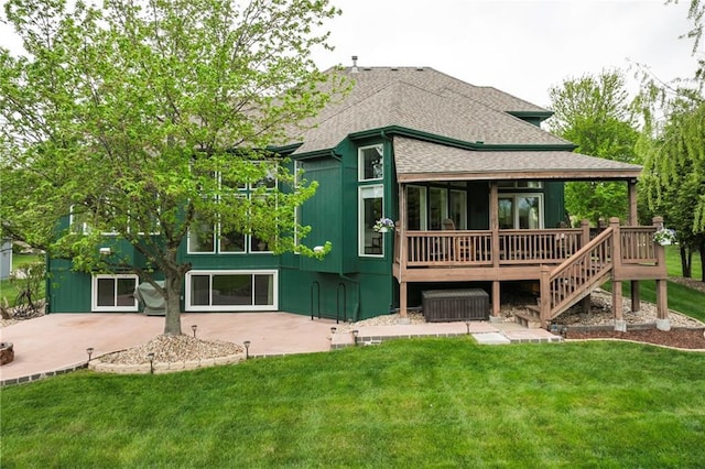 back of house with a lawn, a shingled roof, and a wooden deck