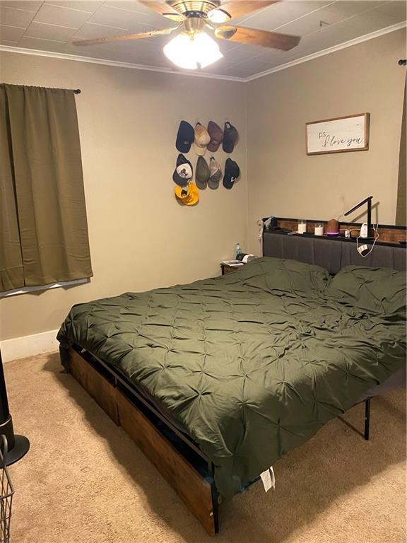 1404 S Barrett Ave, Sedalia, MO 65301 - carpeted bedroom with ornamental molding and ceiling fan