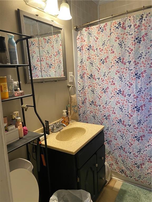 1404 S Barrett Ave, Sedalia, MO 65301 - full bath featuring vanity, toilet, and curtained shower