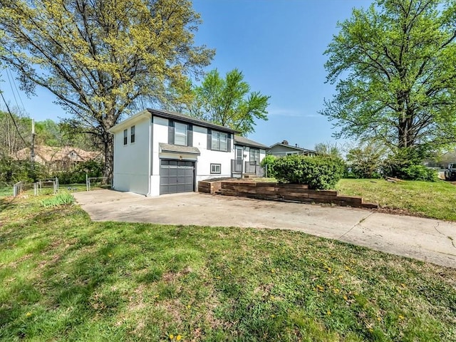 view of front facade with an attached garage, driveway, a front yard, and stucco siding