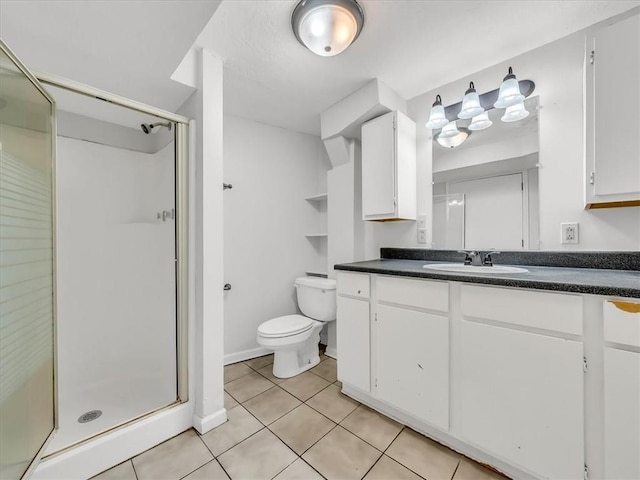 bathroom featuring vanity, toilet, tile patterned flooring, and a stall shower