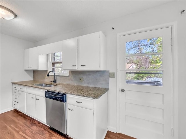 kitchen featuring tasteful backsplash, stainless steel dishwasher, wood finished floors, a sink, and white cabinetry