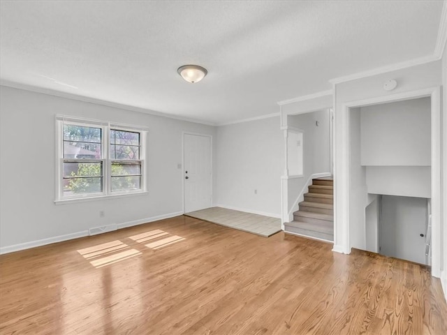 unfurnished living room with stairs, baseboards, ornamental molding, and light wood-style flooring