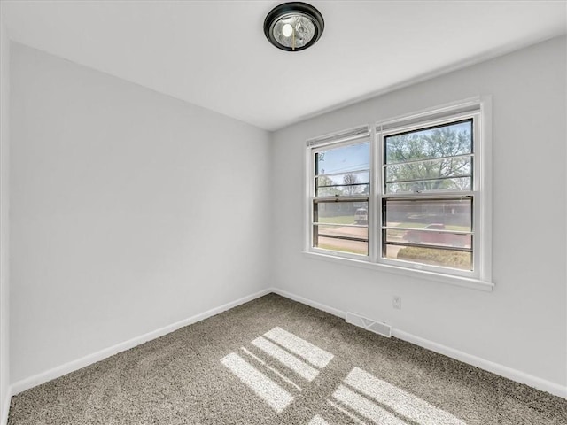 spare room with baseboards, carpet flooring, and visible vents