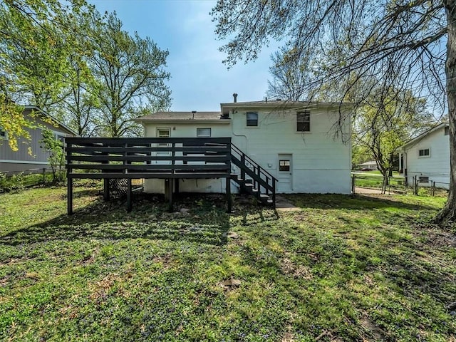 rear view of property featuring a yard, fence, a wooden deck, and stairs