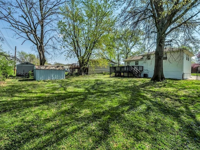 view of yard with a wooden deck and stairs