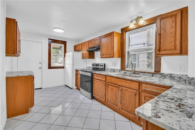 108 N Lawn Ave, Kansas City, MO 64123 - kitchen with freestanding refrigerator, under cabinet range hood, stainless steel electric stove, a sink, and a wealth of natural light