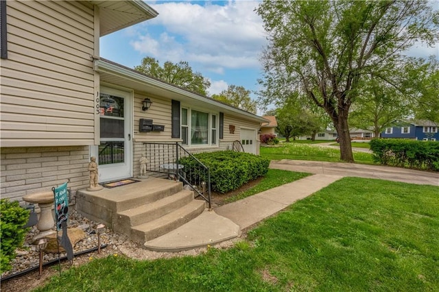 1003 Leone Ave, Sedalia, MO 65301 - view of exterior entry featuring a garage and a yard
