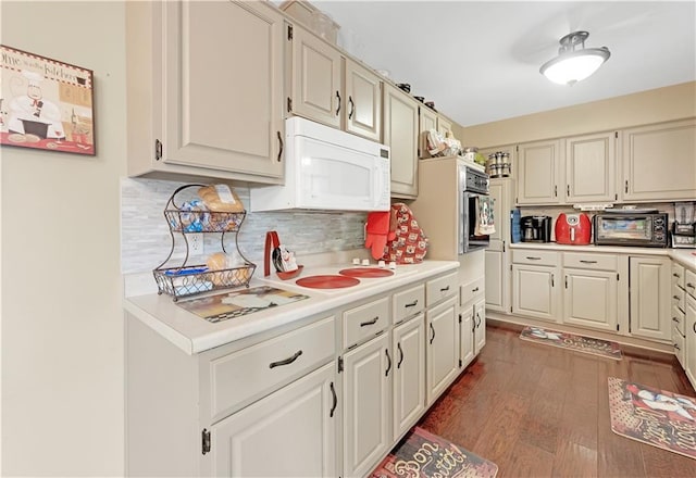 1003 Leone Ave, Sedalia, MO 65301 - kitchen with light countertops, backsplash, dark wood finished floors, and white microwave