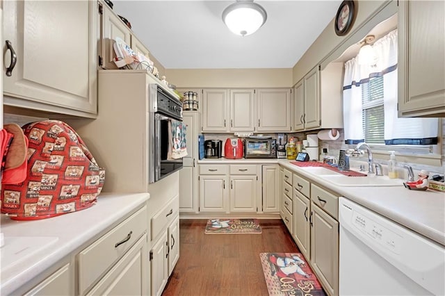 1003 Leone Ave, Sedalia, MO 65301 - kitchen featuring dark wood-style flooring, oven, a sink, dishwasher, and light countertops