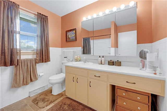 1003 Leone Ave, Sedalia, MO 65301 - full bath with visible vents, tile walls, a wainscoted wall, vanity, and toilet