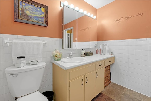 1003 Leone Ave, Sedalia, MO 65301 - bathroom featuring vanity, toilet, tile walls, and a wainscoted wall