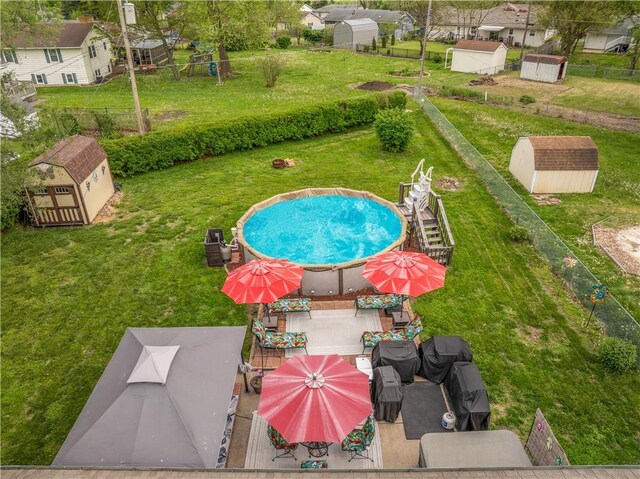 1003 Leone Ave, Sedalia, MO 65301 - view of swimming pool featuring a storage unit, an outdoor structure, and a yard