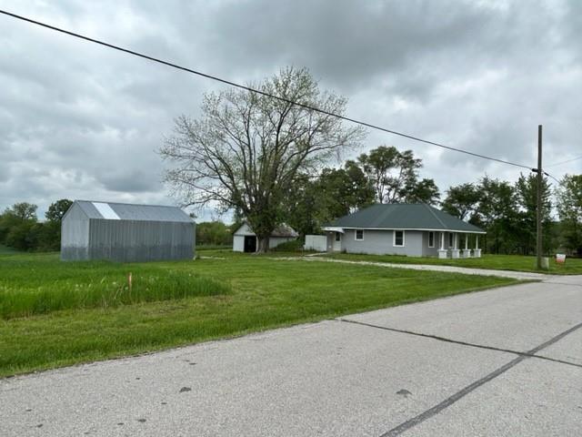 view of front facade with an outbuilding and a front lawn