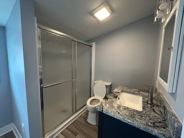 full bath with wood finished floors, toilet, a shower stall, and vanity
