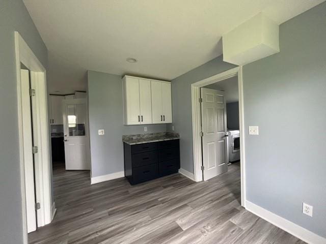 kitchen featuring white cabinetry, wood finished floors, baseboards, and light countertops