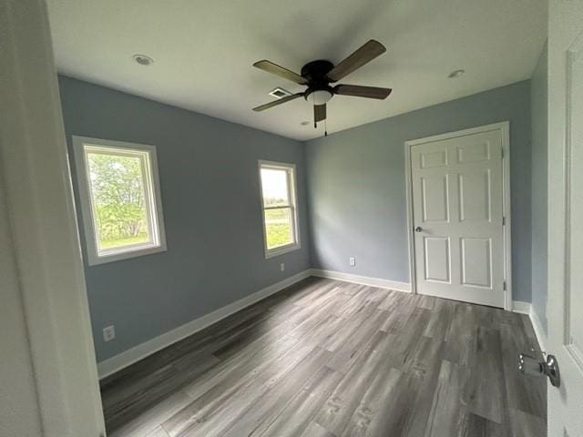 unfurnished bedroom with wood finished floors, baseboards, and a ceiling fan