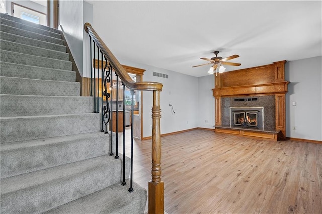 19707 E State Route A, Archie, MO 64725 - unfurnished living room with wood finished floors, ceiling fan, stairs, and plenty of natural light