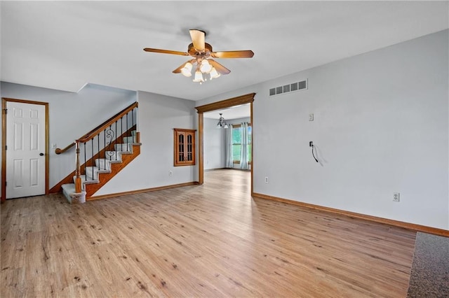 19707 E State Route A, Archie, MO 64725 - unfurnished living room with ceiling fan, light wood-type flooring, stairway, and a chandelier