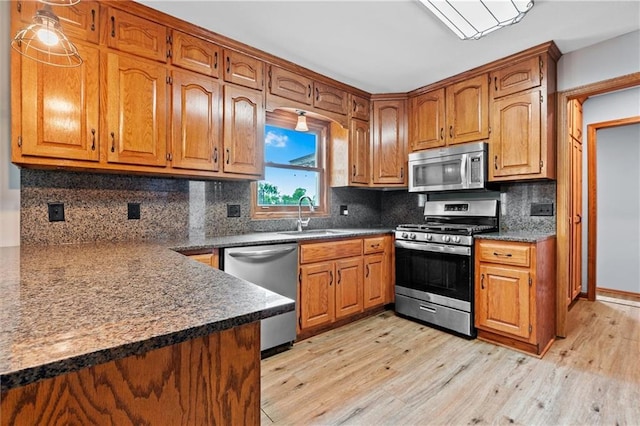 19707 E State Route A, Archie, MO 64725 - kitchen featuring stainless steel appliances, a sink, light wood-type flooring, and brown cabinetry