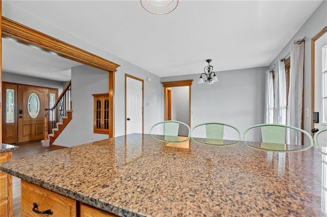 19707 E State Route A, Archie, MO 64725 - kitchen featuring healthy amount of natural light, a chandelier, light stone counters, and wood finished floors