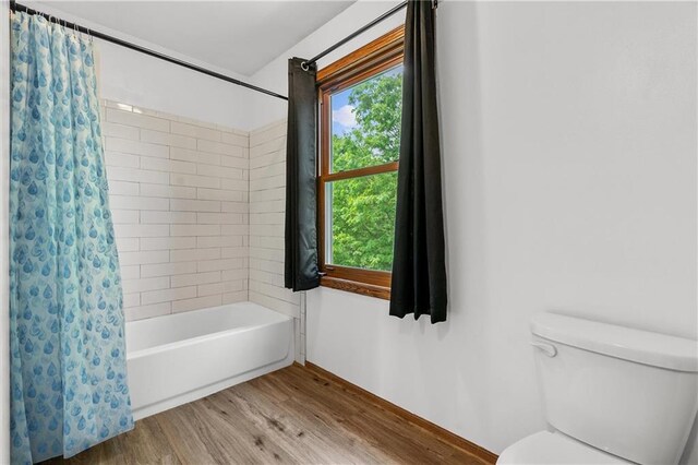 19707 E State Route A, Archie, MO 64725 - full bath featuring wood finished floors, toilet, shower / bath combo, and baseboards