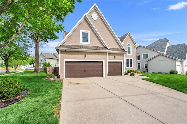 traditional home with a front yard, a chimney, a shingled roof, an attached garage, and driveway