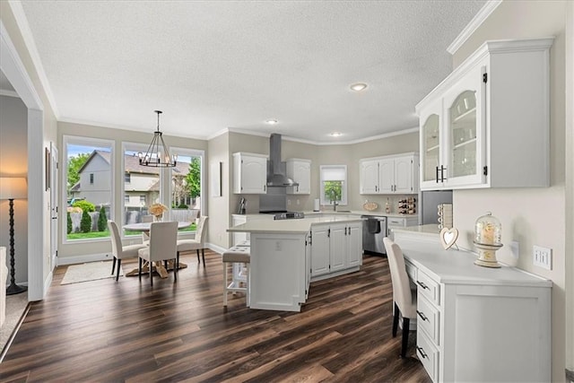 kitchen with wall chimney range hood, dark wood-style flooring, a breakfast bar, dishwasher, and white cabinetry