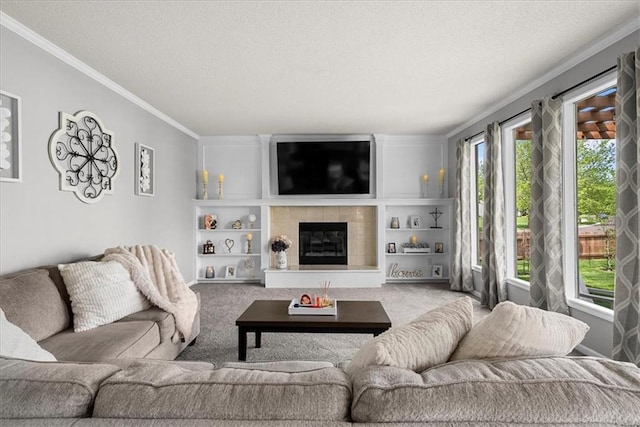 living area with carpet floors, a textured ceiling, ornamental molding, and a tiled fireplace