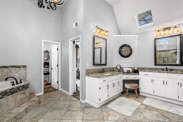 full bathroom featuring vanity, high vaulted ceiling, baseboards, a spacious closet, and visible vents